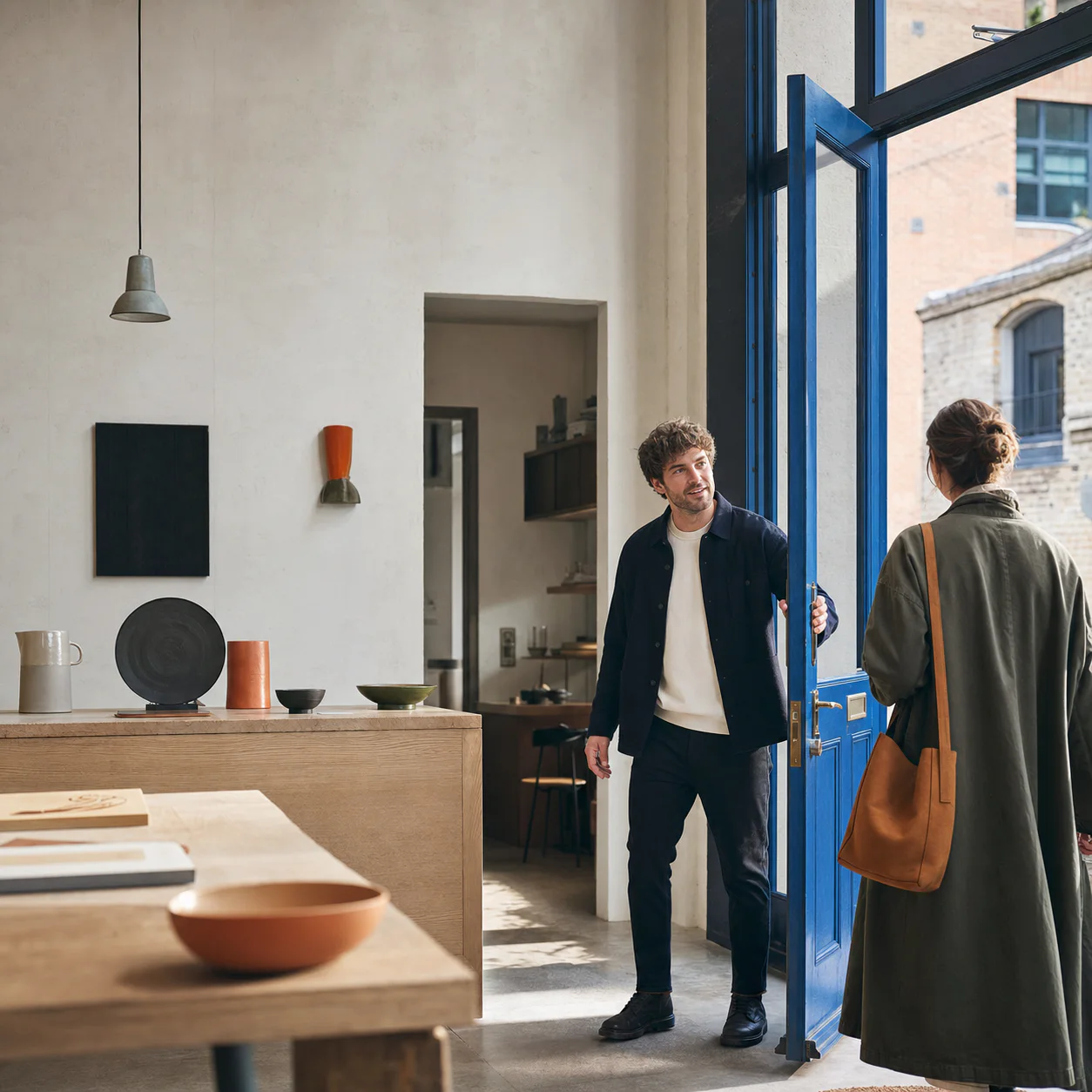 Independent business owner welcoming a customer into a contemporary workshop