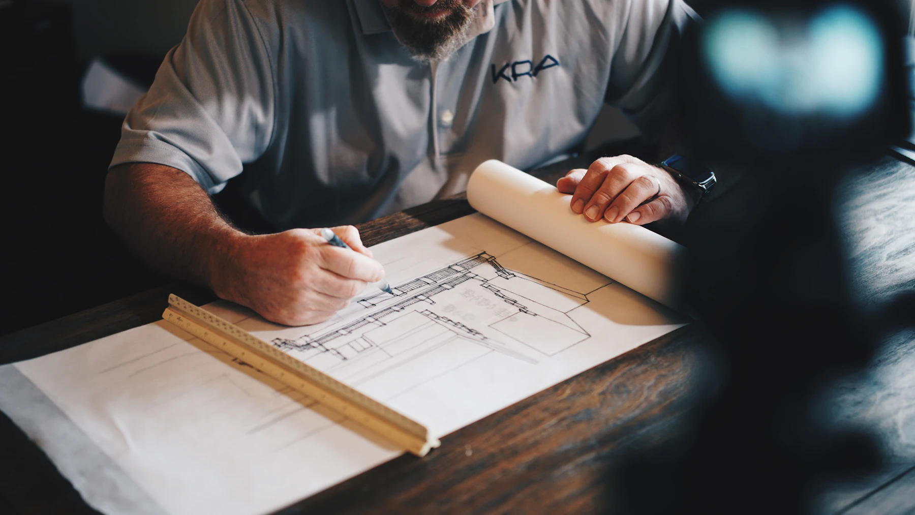 Designer drawing detailed plans at a workbench